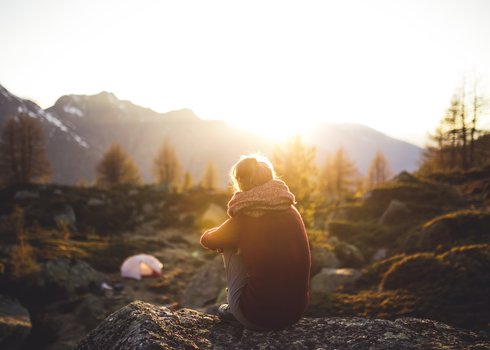 2_Woman dementia caregiver sitting on a rock alone looking at sunrise