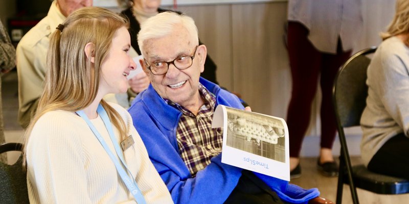 a senior sitting and talking with a volunteer