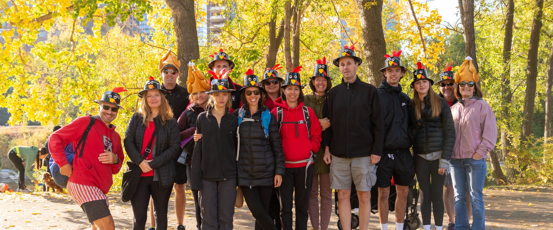 a group of people wearing turkey hats with a autumn backdrop