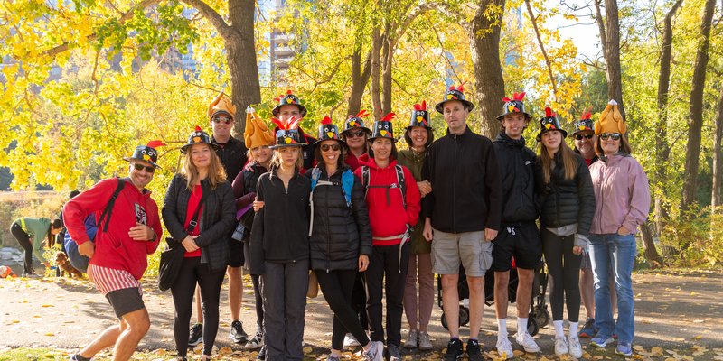 a group of people wearing turkey hats with a autumn backdrop