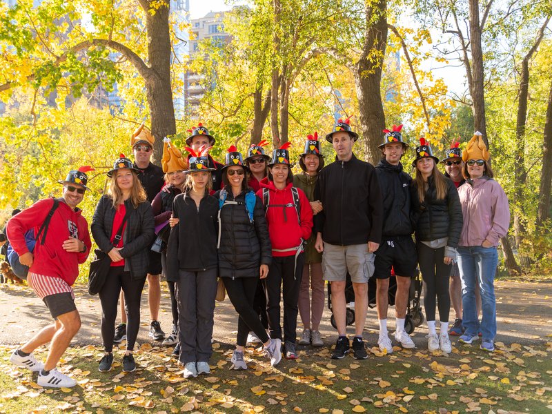 a group of people wearing turkey hats with a autumn backdrop