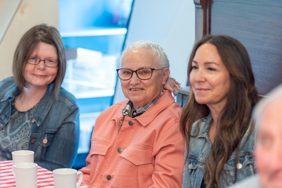 three people sitting with each other and smiling