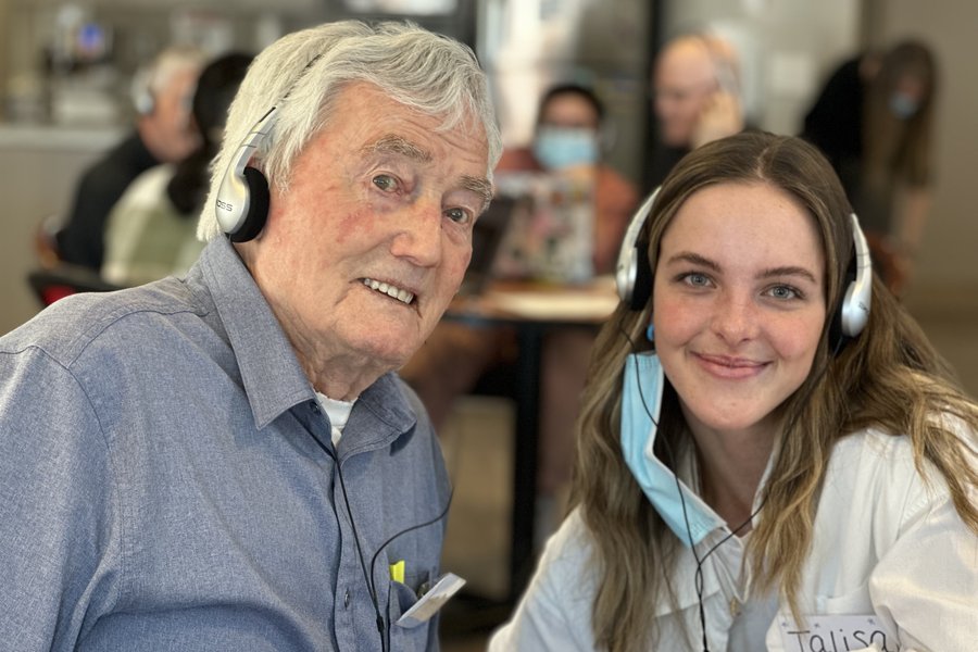 senior and a care partner listening to music