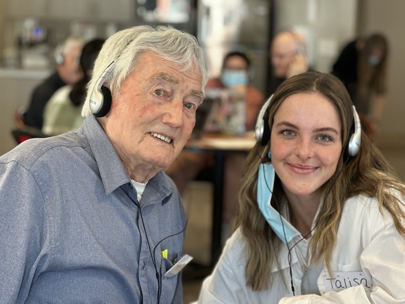 senior and a care partner listening to music