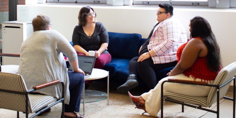 a group of people having a conversation while sitting in a circle