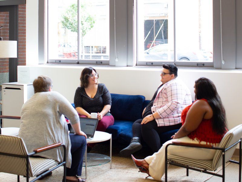 a group of people having a conversation while sitting in a circle