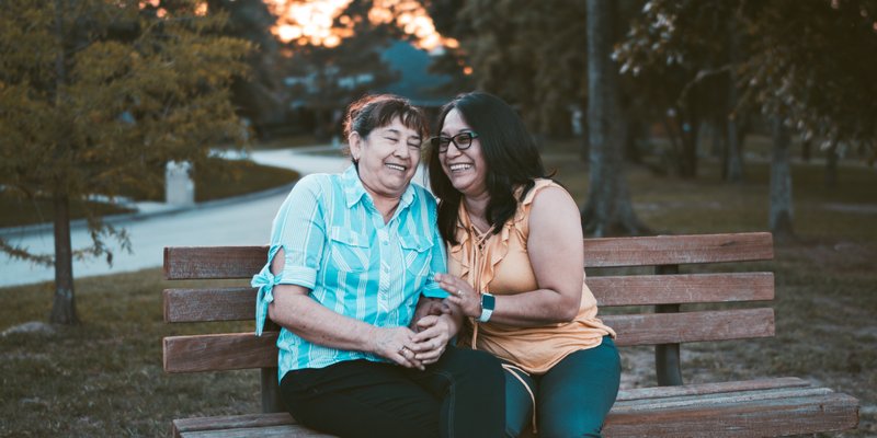 two people sharing a laugh on a bench