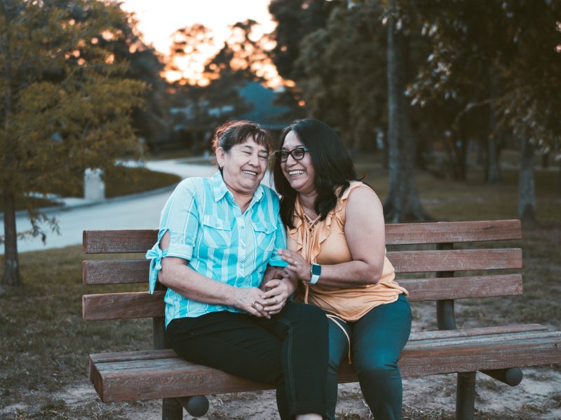 two people sharing a laugh on a bench