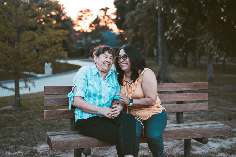 two people sharing a laugh on a bench