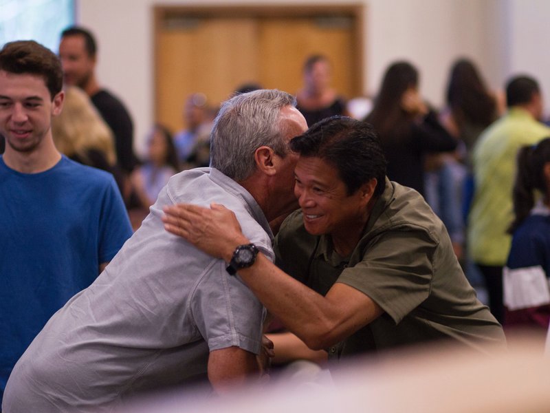 two men embracing in a crowd