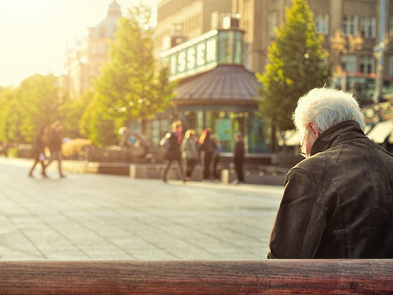 a senior sitting alone on a bench