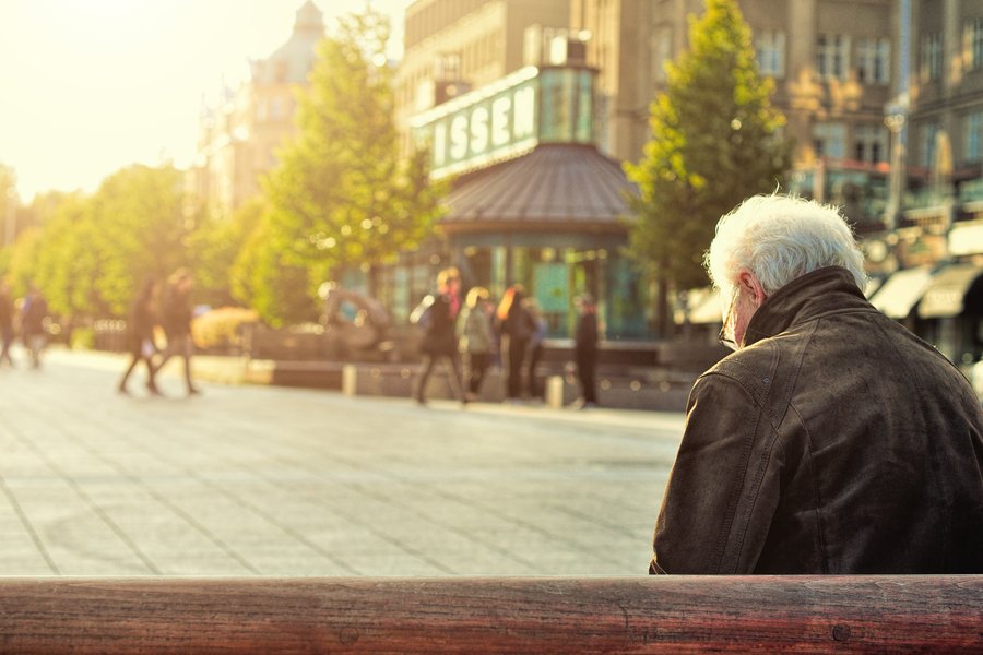 a senior sitting alone on a bench