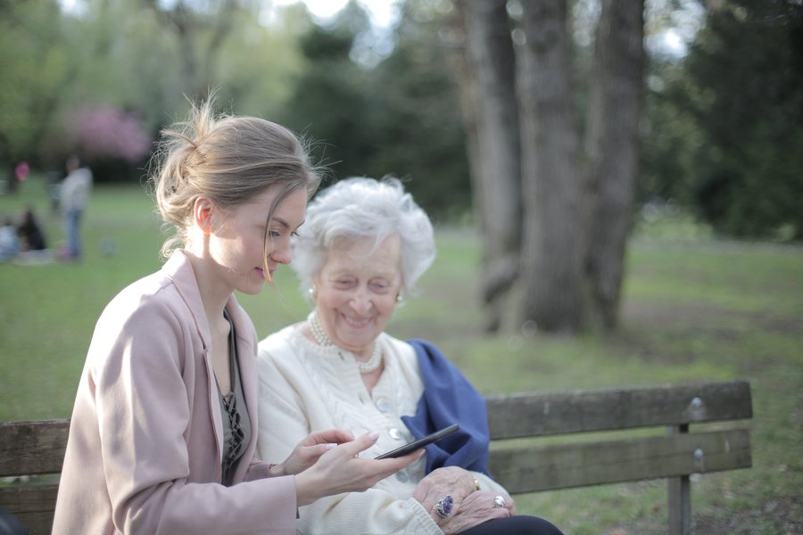 a young woman showing an older woman something on her phone