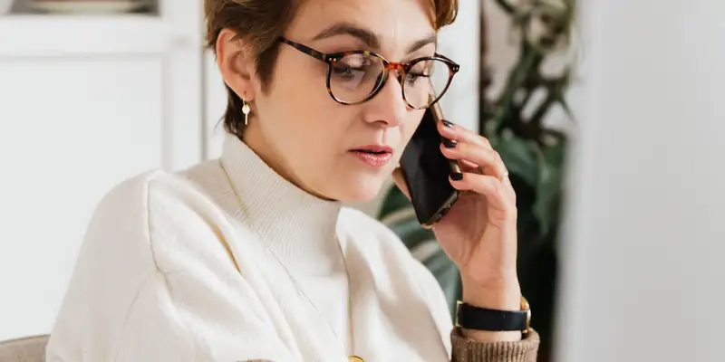 woman on the phone in front of a computer
