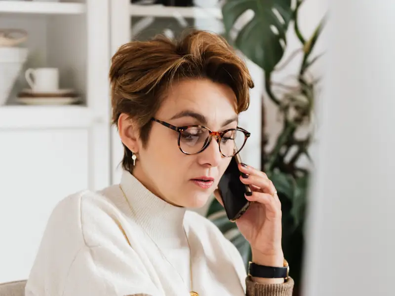 woman on the phone in front of a computer