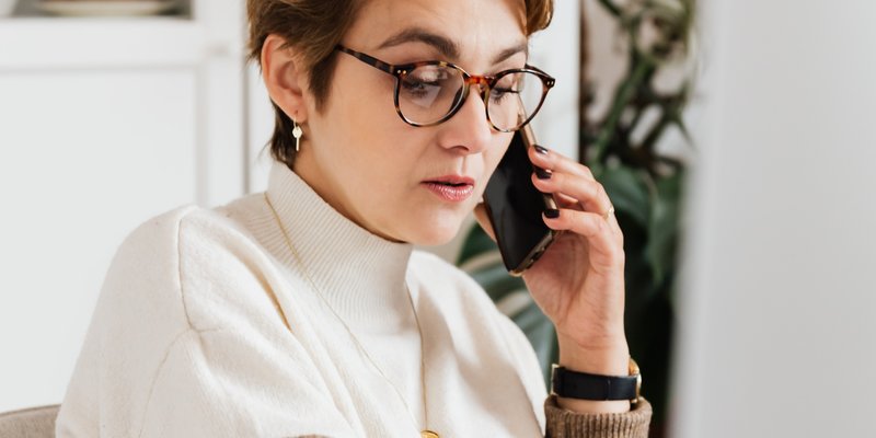 woman on the phone in front of a computer