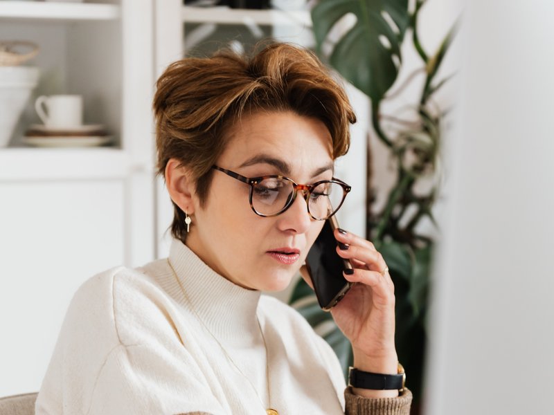 woman on the phone in front of a computer