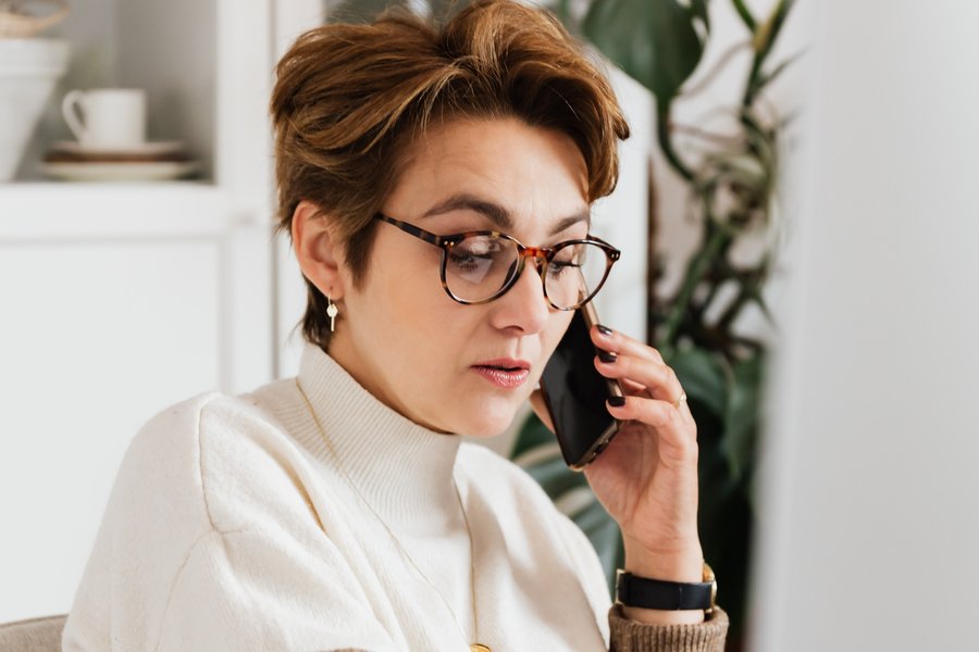 woman on the phone in front of a computer